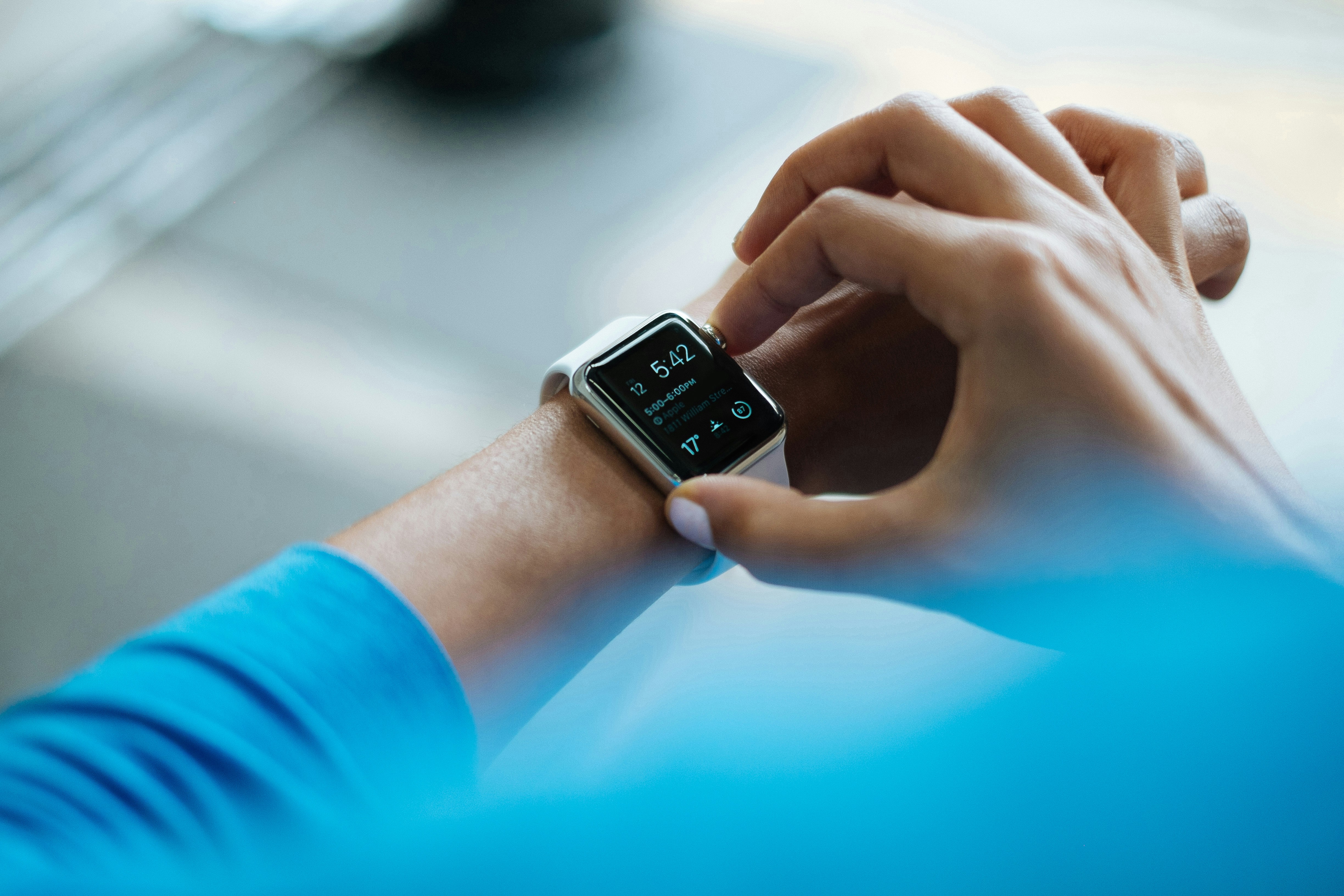 Person interacting with smartwatch, symbolizing portable podcast streaming